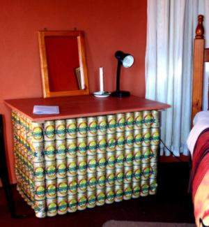 The bedside table was a tribute to somebody's hard drinking habit as it was made of (empty) beer cans.